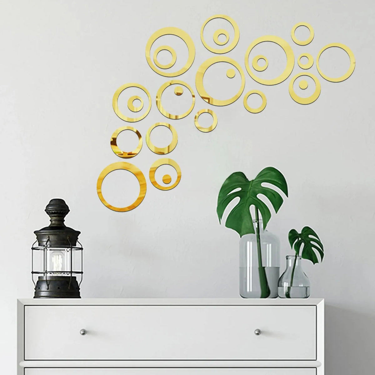 A decorative wall display featuring a collection of gold geometric hollow circles on a white wall.