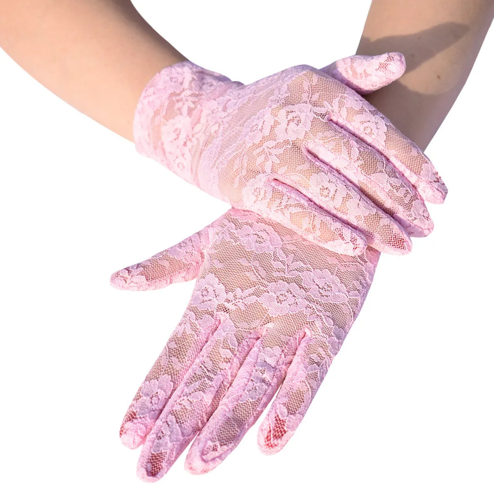 Pink sheer lace gloves worn on a hand, showing delicate floral patterns.