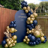 A balloon garland arch featuring navy blue and gold metallic balloons set up outdoors.