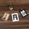 A set of rustic wooden clip photo displays featuring kraft paper frames and photographs, displayed on a wooden surface.
