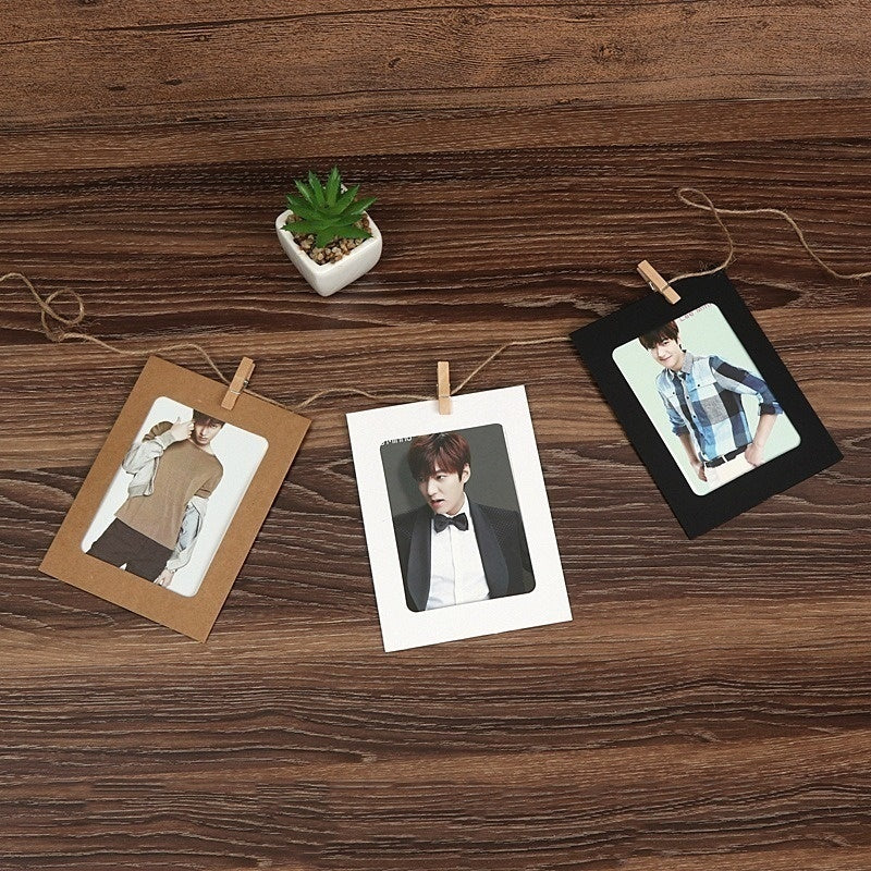 A set of rustic wooden clip photo displays featuring kraft paper frames and photographs, displayed on a wooden surface.