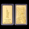 Two gold bullion ingots, one featuring a statue of David and the other an eagle, both marked as 1 Troy Ounce, 100 Mills, and 