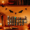 A display of spooky Halloween figurines and a book on a wooden shelf with seasonal decor.