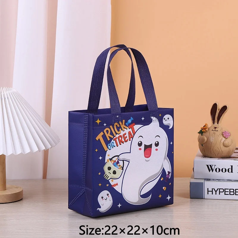 A dark blue non-woven gift tote bag with a white ghost design and stars, shown on a wooden surface.