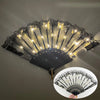 A golden LED dancing hand fan with black accents is shown against a dark background.