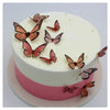White cake decorated with pink accents and edible butterfly paper sheets for cake decorating