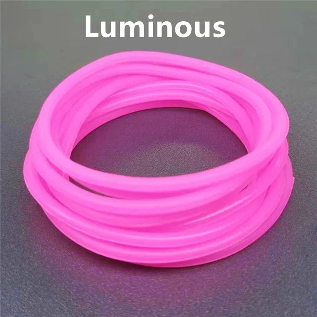 A coil of luminous pink silicone bracelets on a dark surface.