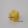 A cluster of yellow soy wax candles, showing a group of small spherical candles.