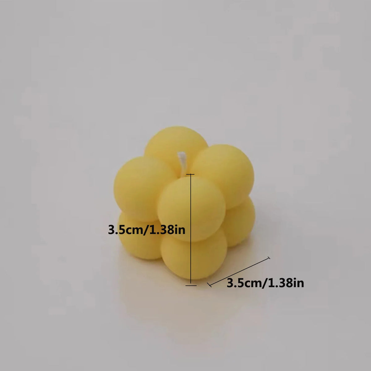 A cluster of yellow soy wax candles, showing a group of small spherical candles.