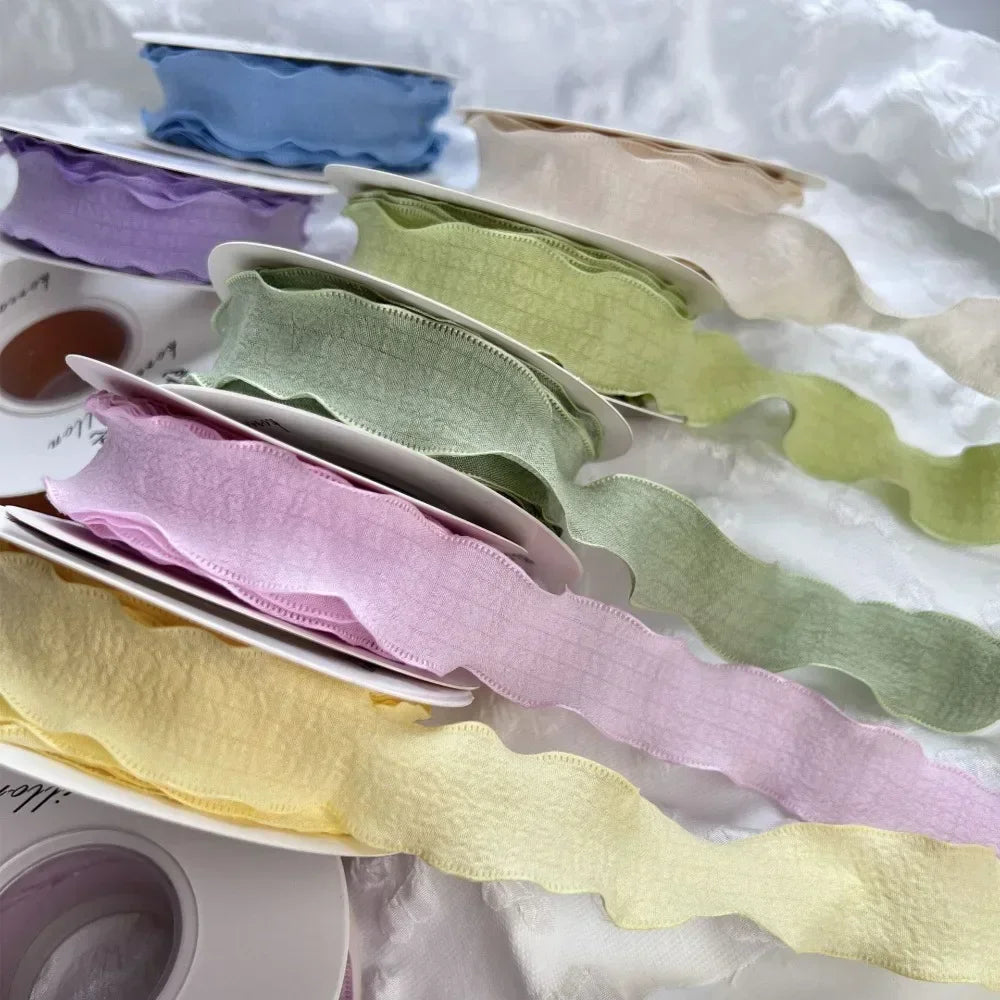 A collection of decorative fishtail yarn ribbons in various pastel shades, including blue, purple, green, and yellow.