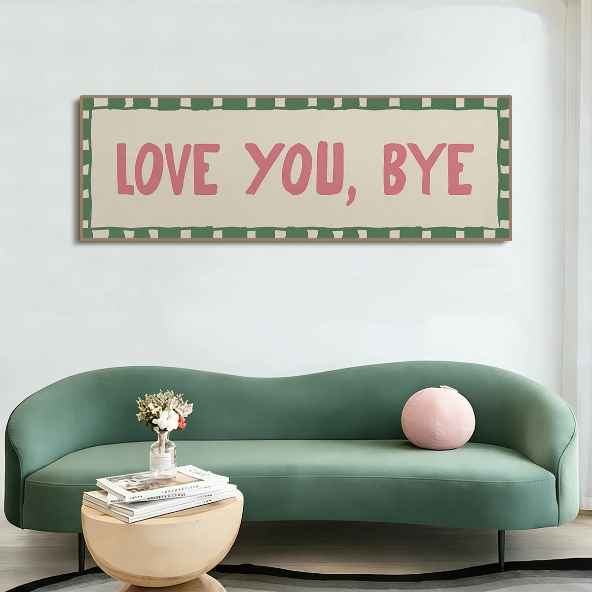 A framed canvas art print featuring the text Love You Bye in pink on a green and white checkered background above a teal sofa