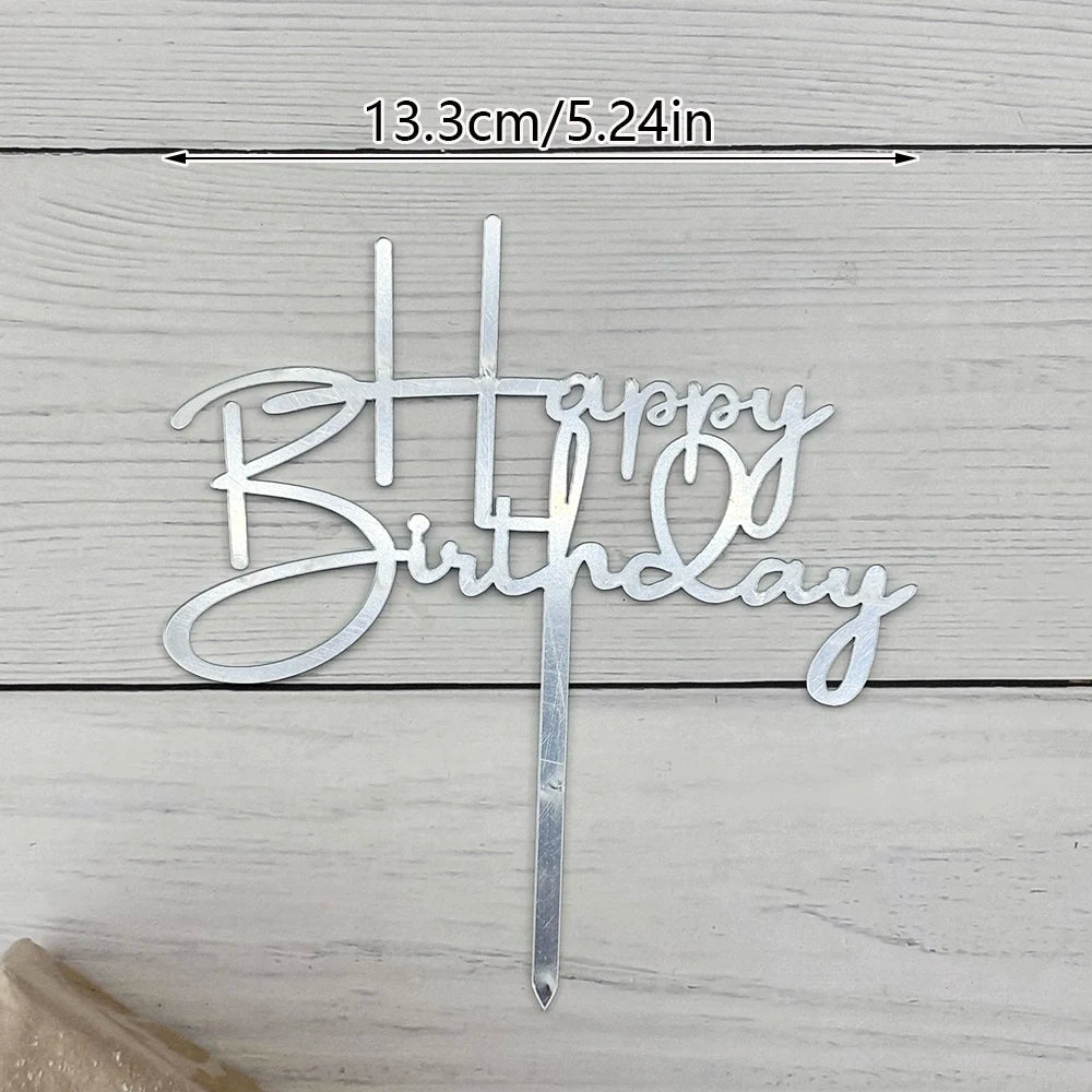 Silver acrylic birthday cake topper with gold lettering spelling out Happy Birthday