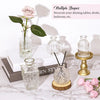 A collection of vintage bud glass vases and decorative items displayed on a marble surface.