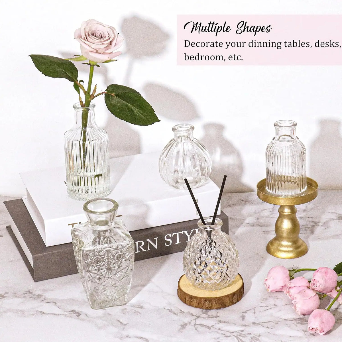 A collection of vintage bud glass vases and decorative items displayed on a marble surface.