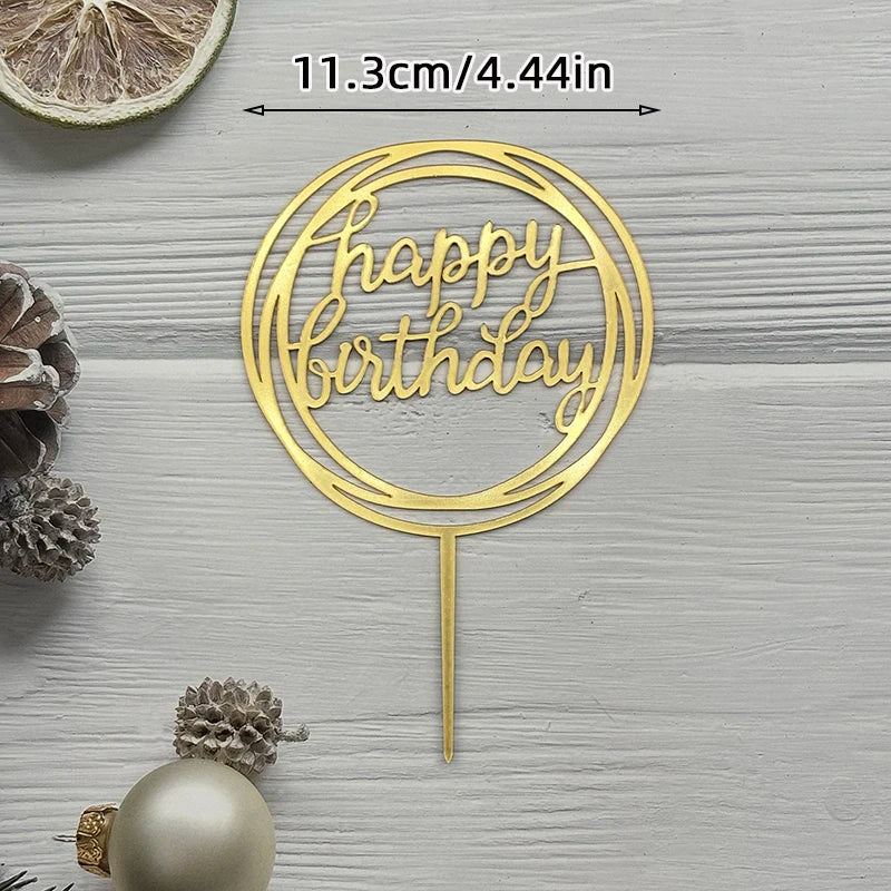 Gold acrylic cake topper with happy birthday text on a stick