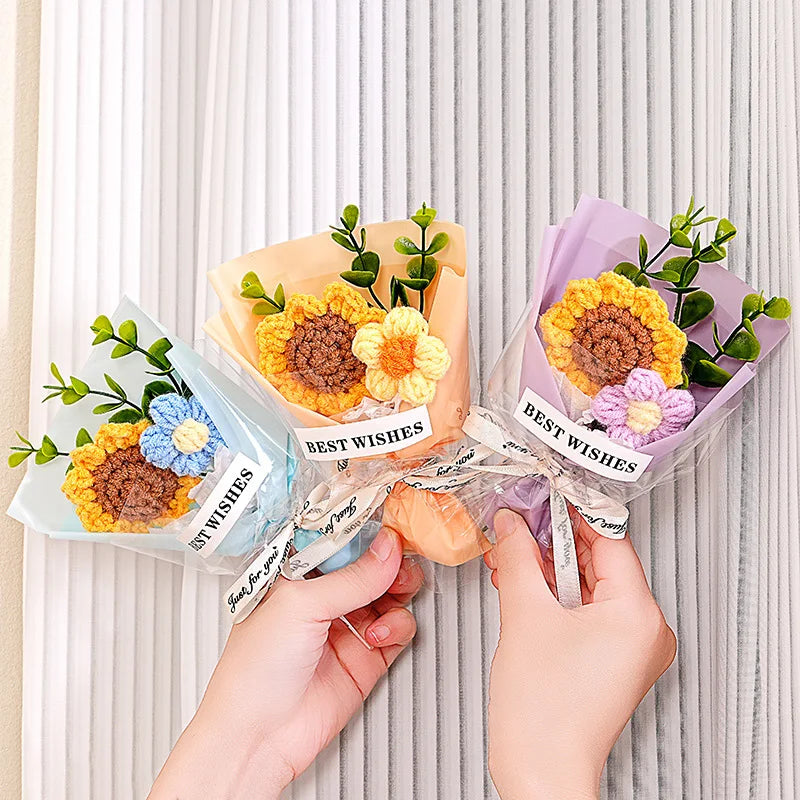 A bouquet of handmade crochet flowers in yellow and purple velvet blooms wrapped in clear paper for gifting