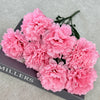A bouquet of pink silk artificial chrysanthemum flowers displayed on a dark box.