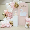 A pink and white balloon garland arch kit featuring latex balloons, gold accents, and a silhouette of a swan on a pink backdr