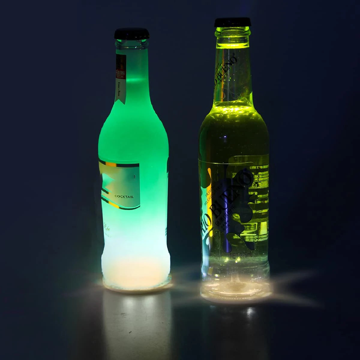 Two glass bottles illuminated by green LED lights, showcasing the luminous effect of the coaster lights.