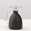 A matte black ceramic vase with a rounded body and narrow neck, shown against a white background.