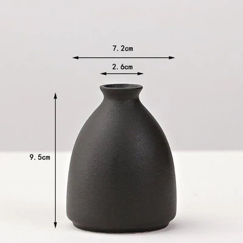 A matte black ceramic vase with a rounded body and narrow neck, shown against a white background.