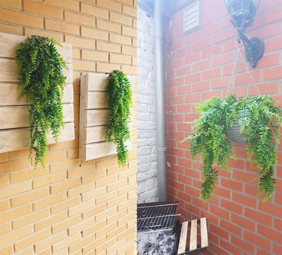 Artificial plant vines hanging on a brick wall next to a white brick wall.