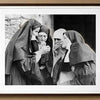 Gravure noir et blanc de trois religieuses fumant dans un intérieur faiblement éclairé.