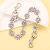 Silver bag chain extender with pink rhinestone charms displayed on a white background.