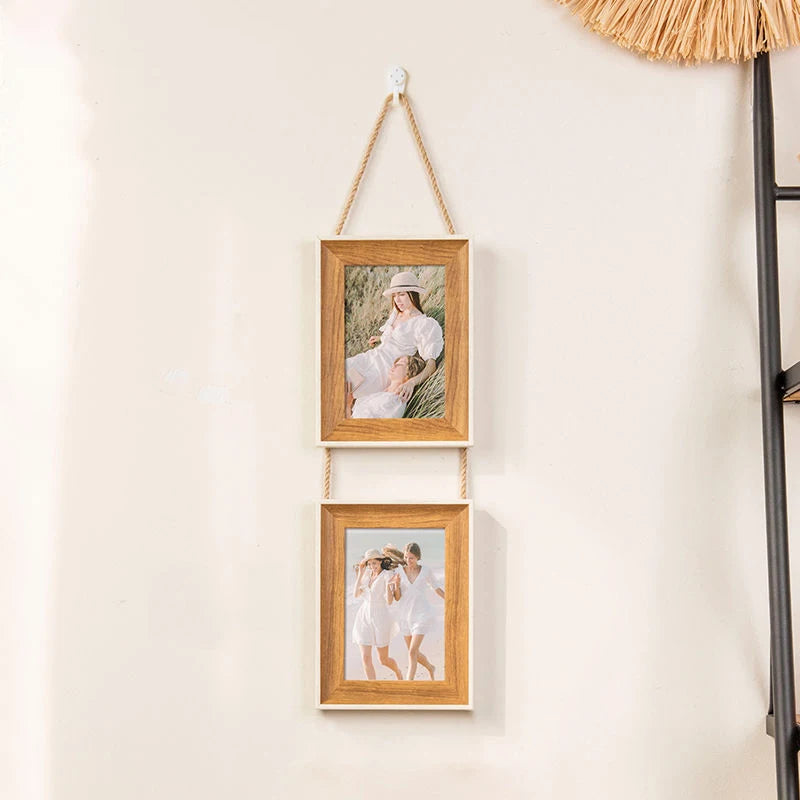 A set of two rustic wooden collage photo frames with natural twine hanging on a wall.