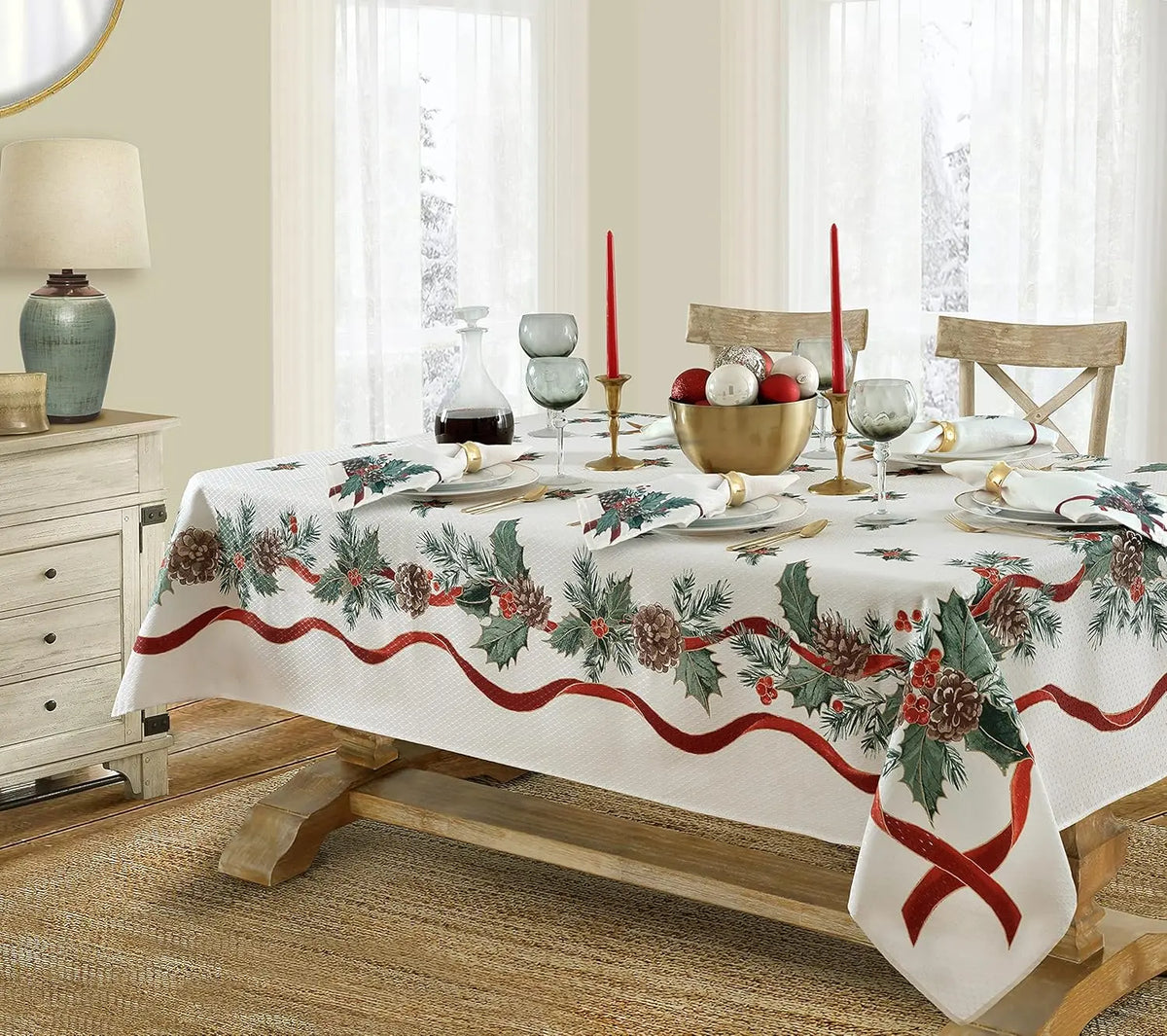 A Christmas poinsettia rectangle tablecloth set for a dining table with candles and tableware.