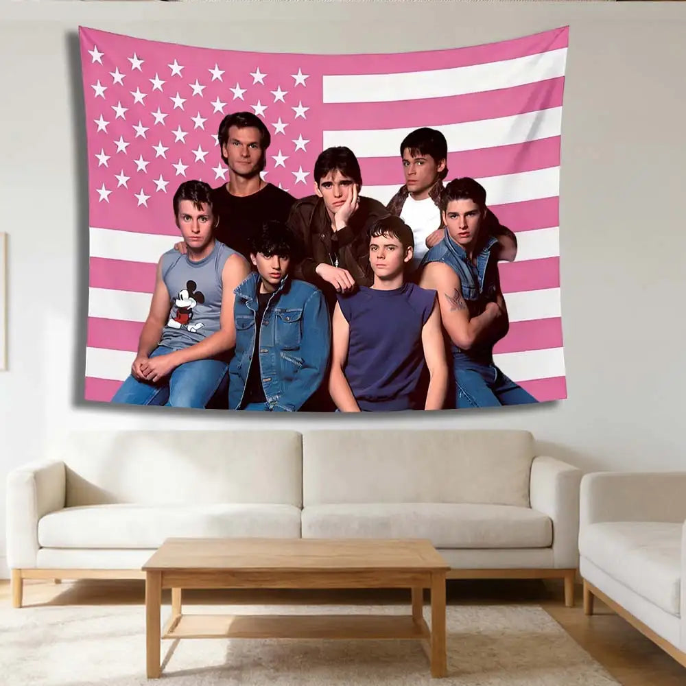 A tapestry featuring a pink and white striped American flag design with seven young men posing in front of it.