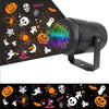 An outdoor LED projector light featuring a dark background with colorful Halloween and Christmas patterns.