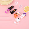Reusable silicone straw covers shaped like Halloween cats and a lemon on a pink background