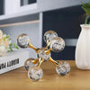 A gold-toned molecular sculpture desk decor featuring spherical glass orbs with glitter inside.