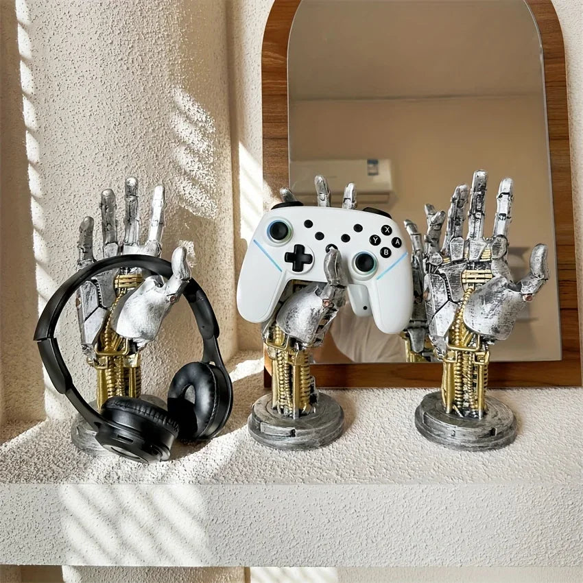 A silver robotic hand and a white game controller are displayed on a shelf with a mirror.