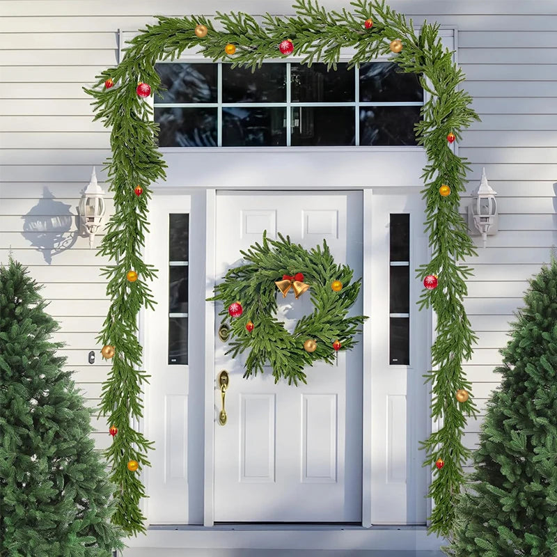 Green Norfolk pine Christmas garland with optional lights decorating a white door.