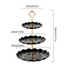 A two-tier serving stand featuring three black, scalloped plates with gold accents.