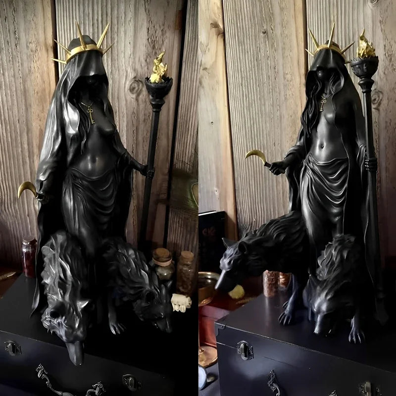 A dark resin statue of a goddess with a crown and staff, standing over a black animal.