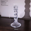 Elegant clear glass pillar candle holder with a decorative base and tapered shape.