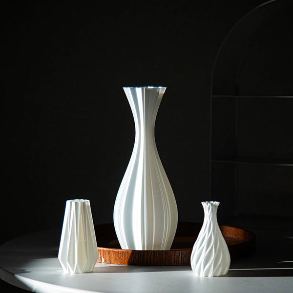 A collection of white ceramic vases of varying shapes and heights displayed on a dark wooden tray.