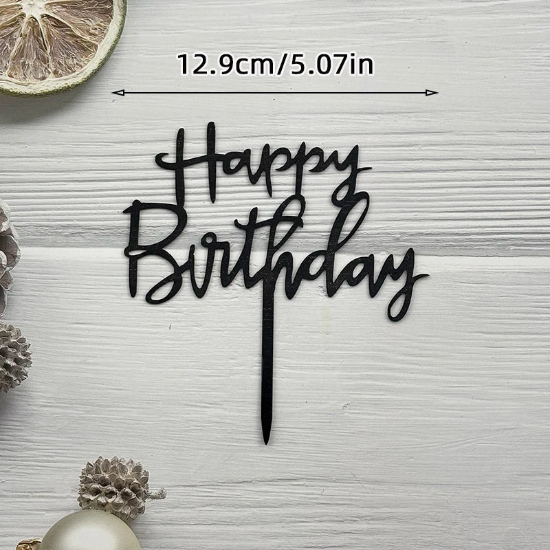 Elegant acrylic birthday cake topper with black lettering and a gold accent on a white wooden background.