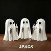 A pack of three white ghost figurines with playful poses displayed on a brown surface.