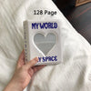 A white photo album titled My World with a heart cutout on the cover, resting on a white sheet.