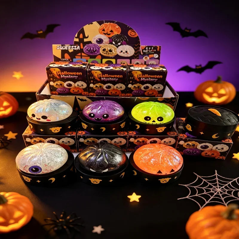 A collection of Halloween themed squishy blind box toys and pumpkins displayed on a dark surface.