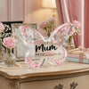 Elegant pink acrylic butterfly plaque for gifts displayed on a wooden surface with flowers and books.