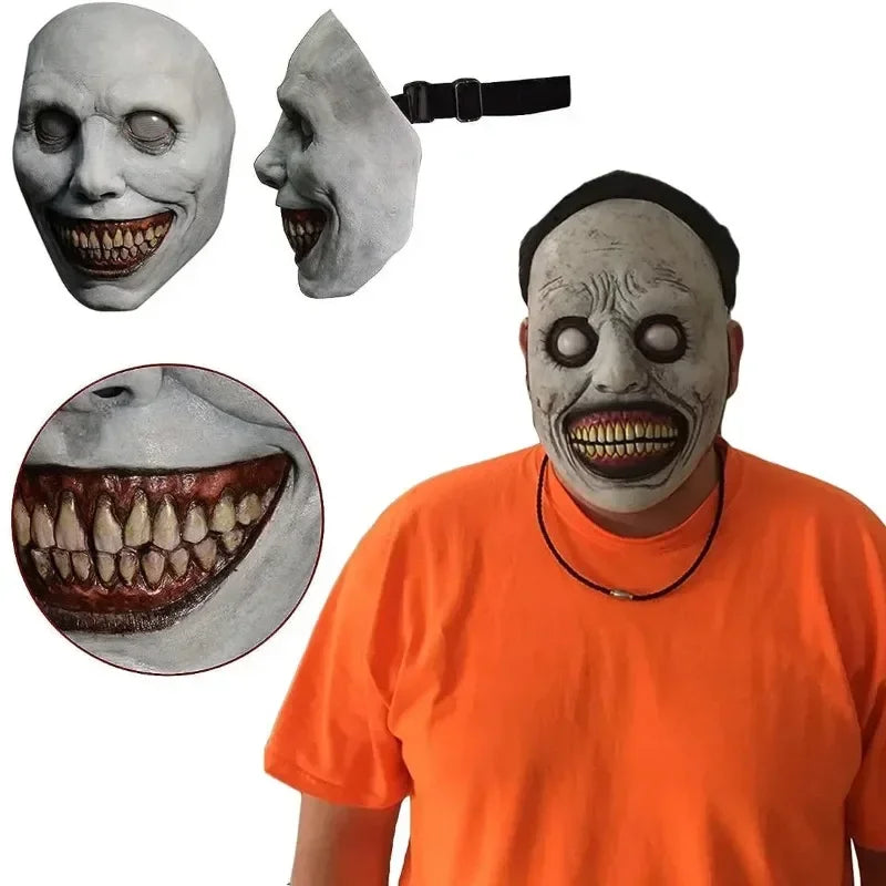 A person wearing a realistic smiling demon latex mask with dark features and a black strap.