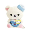 A white Rilakkuma plush bear with blue accents and a yellow tag on its chest.