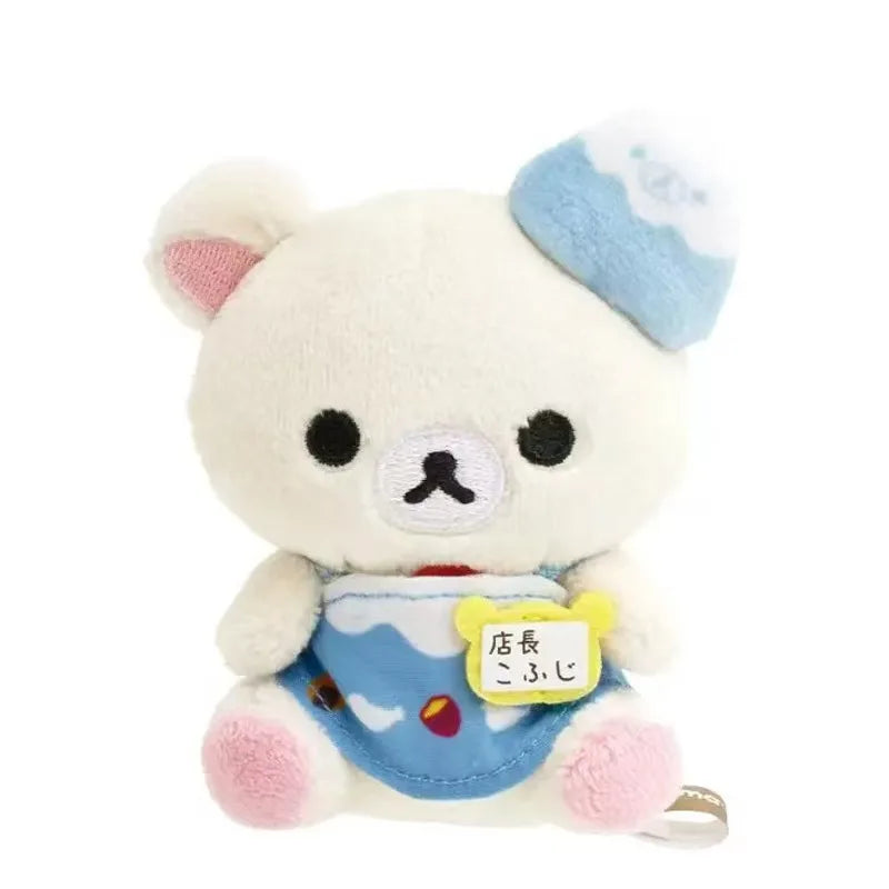A white Rilakkuma plush bear with blue accents and a yellow tag on its chest.