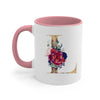 A pink ceramic coffee mug featuring a large gold letter initial decorated with floral accents.