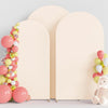 A display of pink and yellow balloons arranged in a vertical garland next to two cream-colored arch stand backdrops.